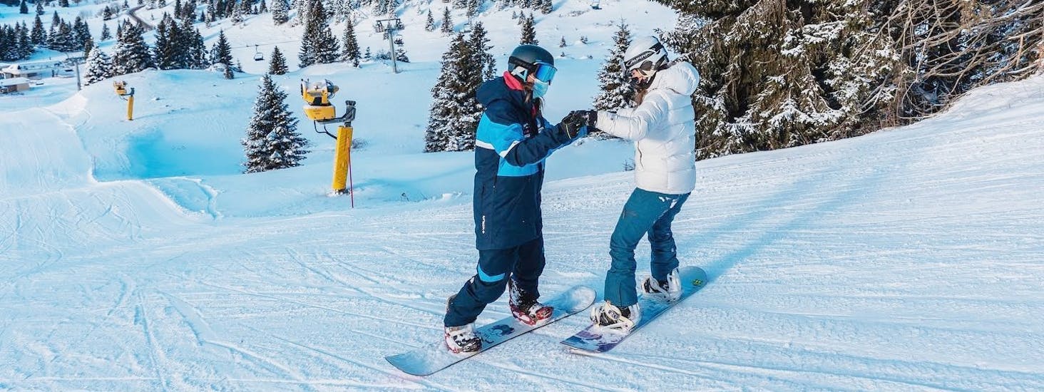 An instructor with a snowboarder during the Private Snowboarding Lessons for Kids & Adults of All Levels.