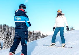 Uno snowboarder impara le tecniche basiche durante le Lezioni private di snowboard per tutte le età e i livelli con Scuola Sci Scie di Passione Folgaria.