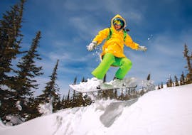 Een snowboarder maakt een sprong tijdens snowboardlessen voor beginners met Skischule Innsbruck.