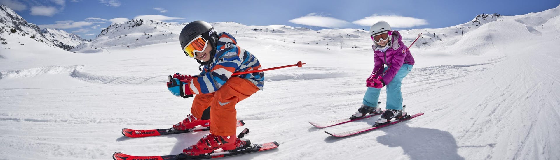 Children race down the slopes at the kids ski lessons (4-8 y.) for all levels incl. equipment hire with Ski School Vacancia Sölden.
