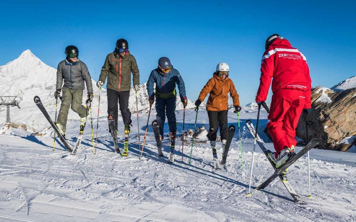Clases de esquí para adultos (a partir de 15 años) para todos los niveles Los participantes de las clases de esquí para adultos - Todos los niveles con Zermatters, calientan motores para un día en las pistas.