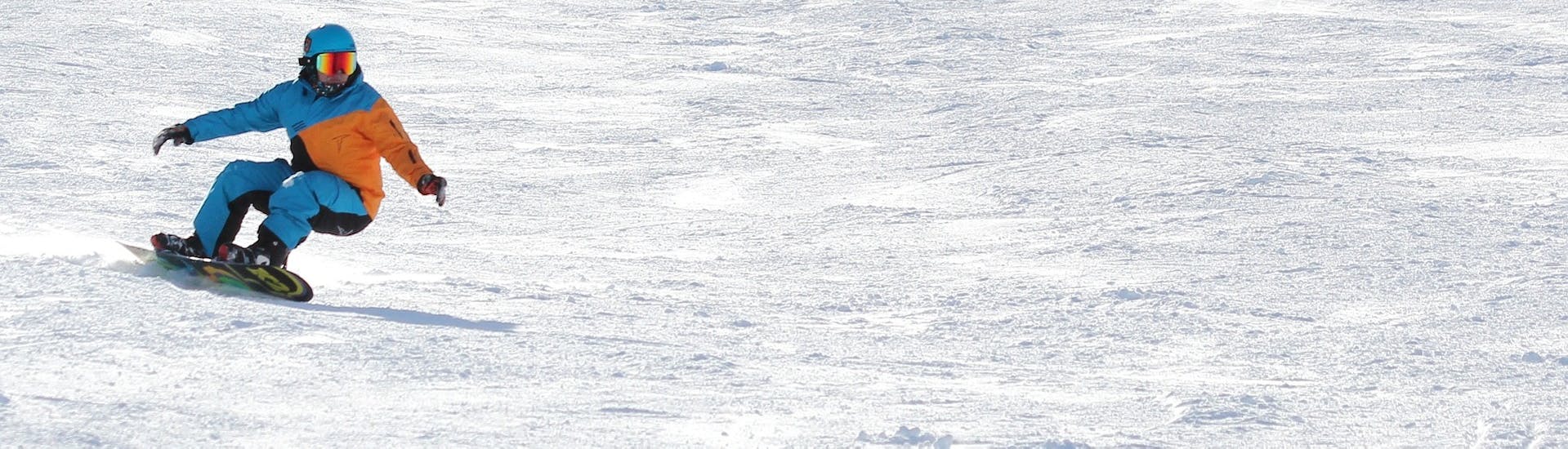 Ein Snowboarder flitzt die Piste hinunter beim Snowboardkurs für Kinder & Erwachsene mit Erfahrung mit Ski-fun in Flumserberg.
