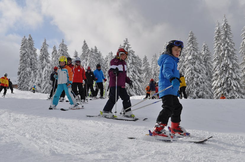 Kids ski behind the instructor at the kids ski lessons (9-13 y.) for all levels with the ON SNOW Ski School Feldberg.