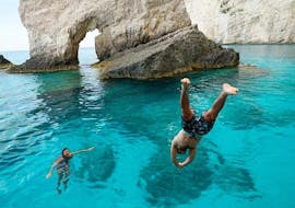 Two people swimming in the sea close to the Blue Caves during the 1 Day Boat & Bus Trip from Zakynthos to Shipwreck Beach and the Blue Caves with Abba Tours Zante.