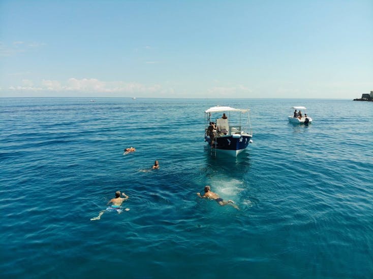 Foto di persone che nuotano durante la sosta per lo snorkeling del Giro in barca a Cefalù con snorkeling e aperitivo con Escursioni in barca La Niña.