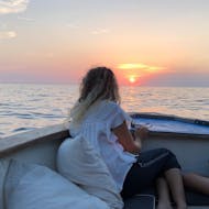 Una donna si gode il tramonto durante il giro privato in barca al tramonto lungo le Cinque Terre con Aquamarina Cinque Terre.