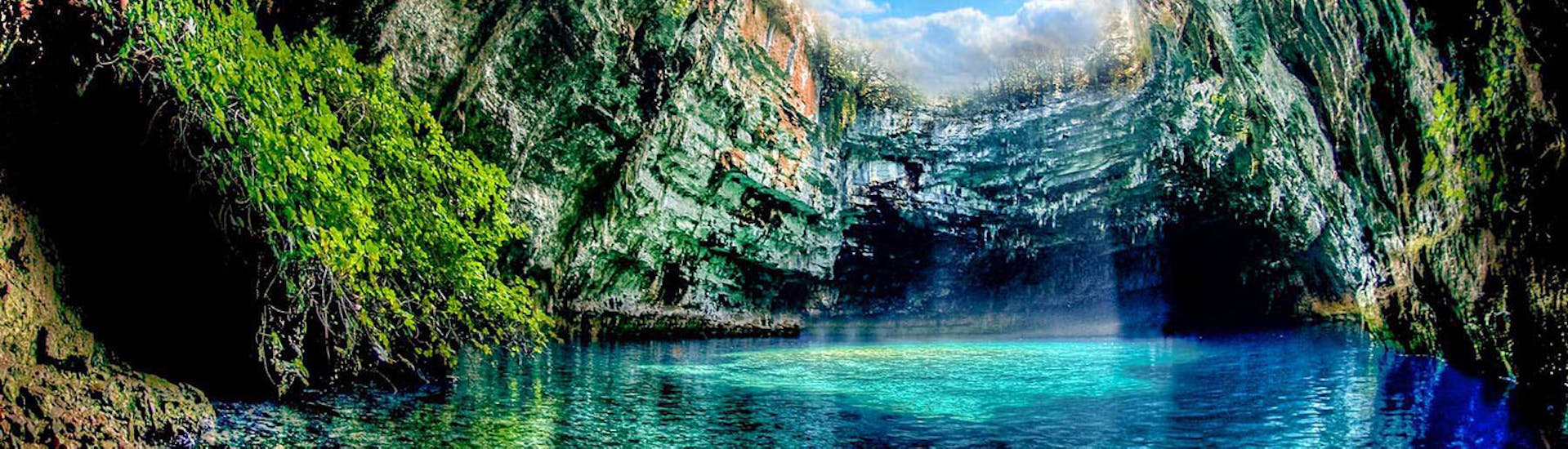 Die Melissani Höhle mit ihrem innenliegenden See und dem offenen Dach während der Bootstour & Bustour von Zakynthos nach Kefalonia mit Abba Tours Zante.