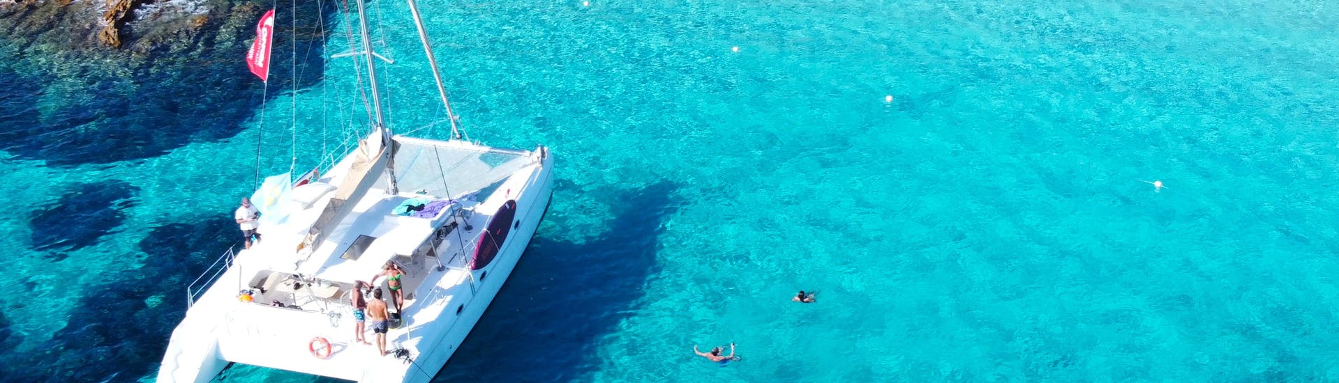 Le catamaran est amarré dans l'archipel de la Maddalena est des usagers se baignent autour