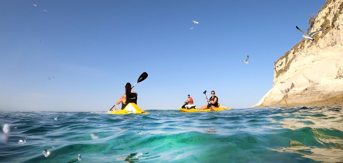 Alcune persone pagaiano nella baia di St. Tomas durante il Kayak da mare a Marsaskala con  Sensi Watersports Malta.
