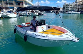 Un hombre a bordo de un barco sin licencia alquilado a Oceanautic de hasta 6 personas navegando a lo largo de la costa de Benalmádena.