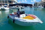 Ein Mann fährt mit einem von Oceanautic gemieteten, mit einem Boot ohne Führerschien mit bis zu 6 Personen an der Küste von Benalmádena entlang.