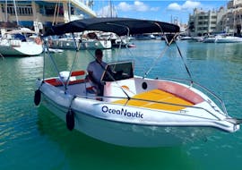Ein Mann fährt mit einem von Oceanautic gemieteten, mit einem Boot ohne Führerschien mit bis zu 6 Personen an der Küste von Benalmádena entlang.