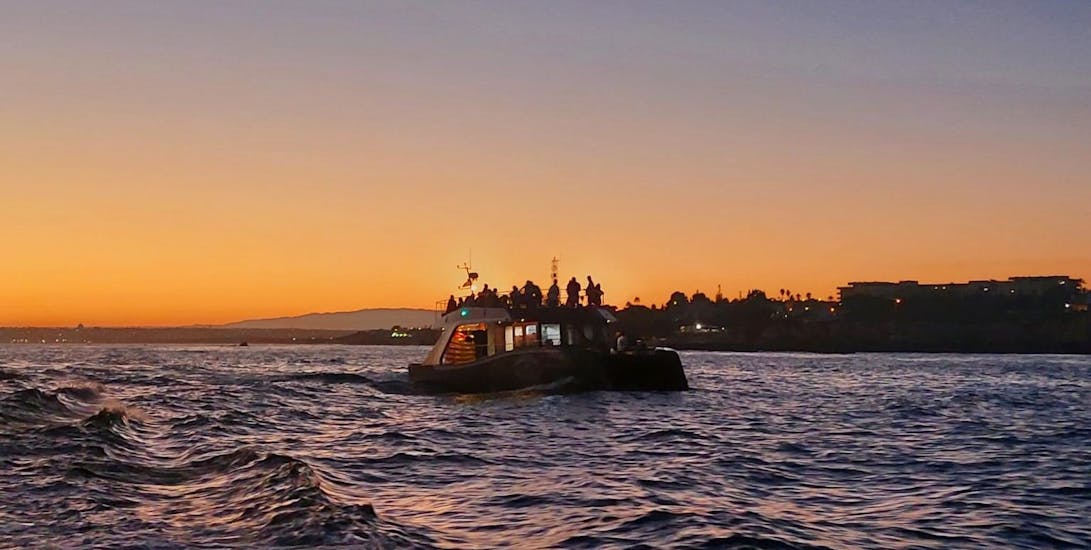 De boot van SeaAlgarve Albufeira op zee tijdens de Catamarantocht bij zonsondergang naar de Benagil Grot.