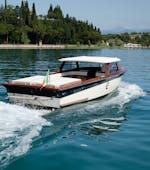 Ein Holzboot im venezianischen Stil, das auf dem Gardasee fährt, während der privaten Bootstour auf dem Gardasee mit Aperitif mit Consolini Boats.