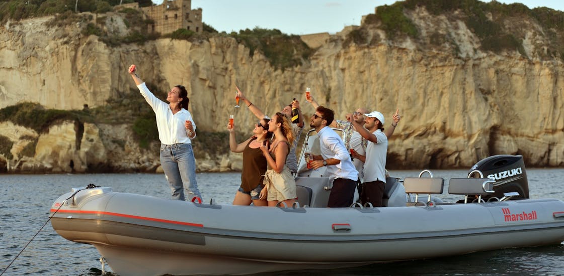 Persone che si divertono sull'imbarcazione durante il giro in gommone da Napoli lungo la costa con aperitivo al tramonto organizzato da Seaside Napoli.