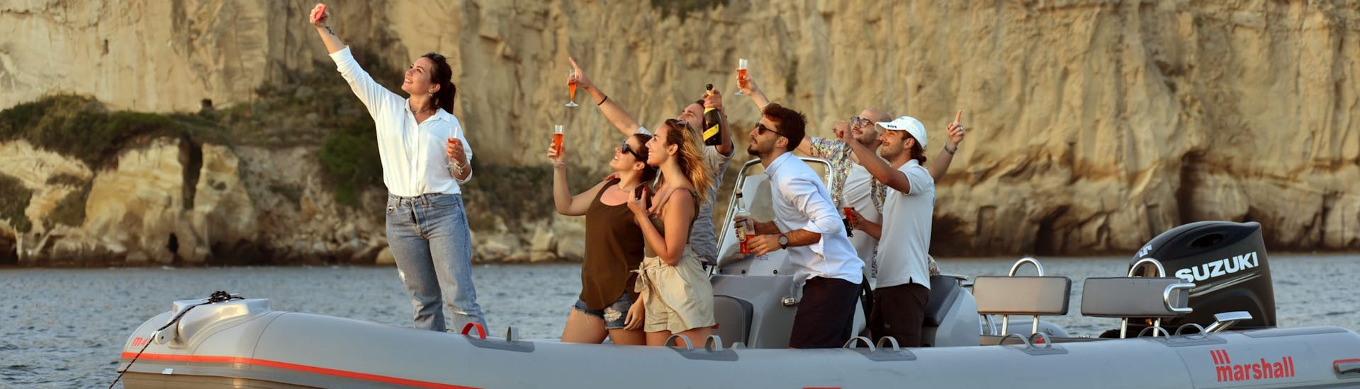 Les gens sur le bateau s'amusent pendant Balade privée en bateau semi-rigide au coucher du soleil depuis Naples, le long de la côte, avec Apéritif avec Seaside Napoli.