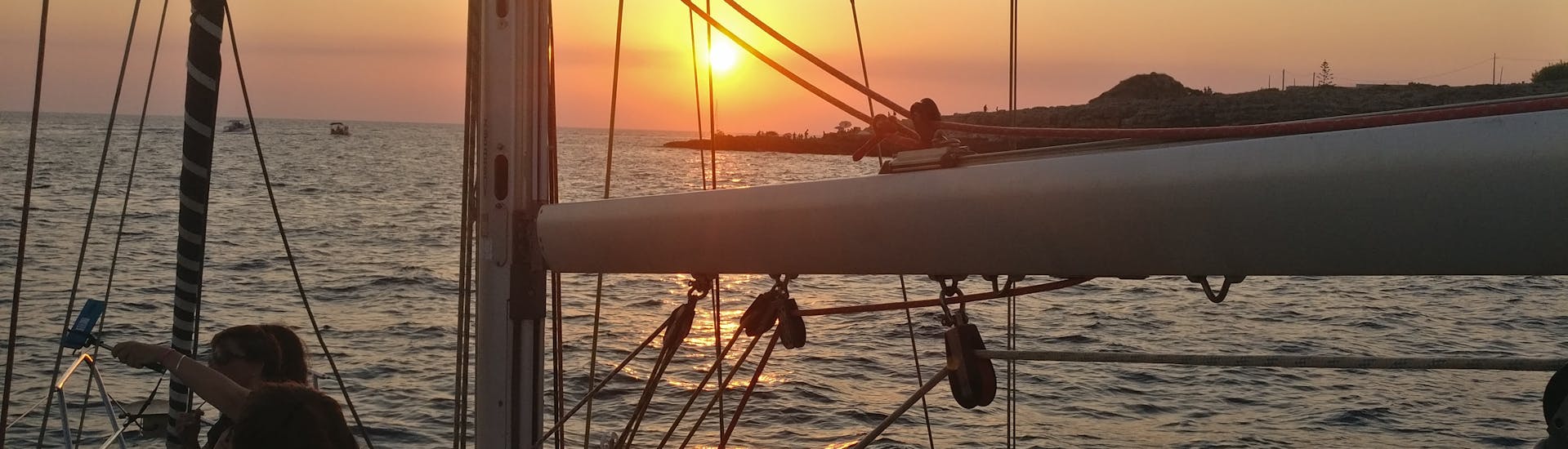Zonsondergang vanaf de boot tijdens de Zeiltocht bij zonsondergang van Leuca naar de kust van Salento met Apéritif met 40° Parallelo Leuca.