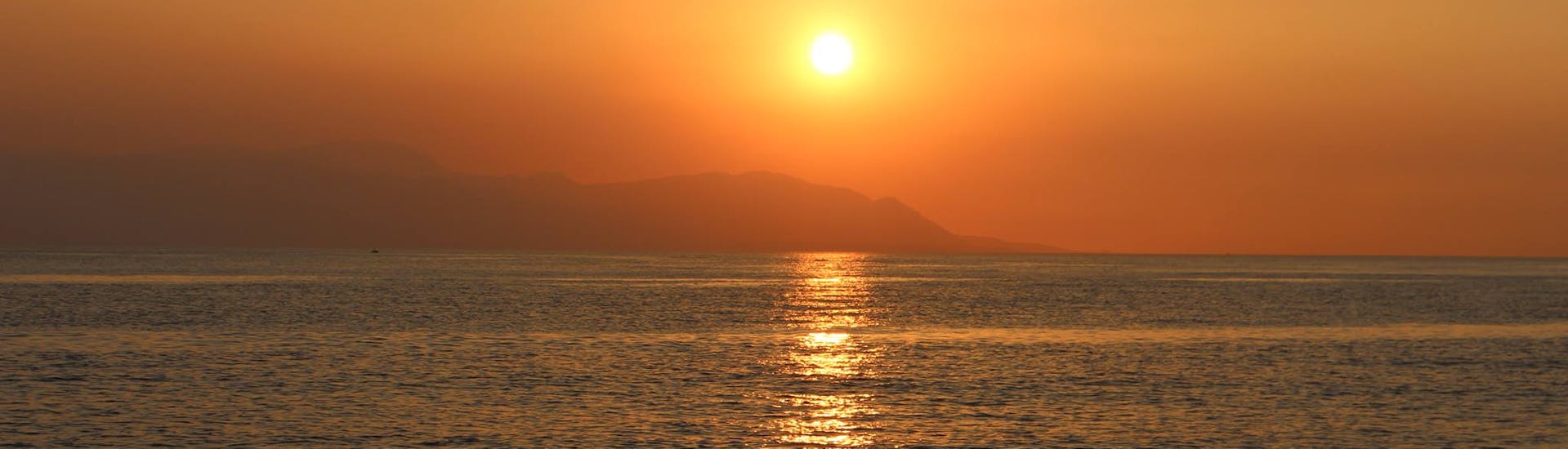 Blick auf den Sonnenuntergang vom Boot aus während der Bootsfahrt von Athen mit Abendessen und Schnorcheln.