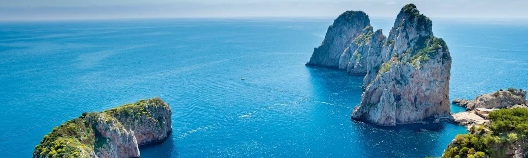 Vista dei Faraglioni durante la gita in barca da Pozzuoli a Capri e Ischia con pranzo organizzata da Gestour Pozzuoli.
