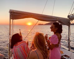 Unas chicas se divierten en un paseo en velero privado en Port d' Andraitx al atardecer con Vayu Charters.