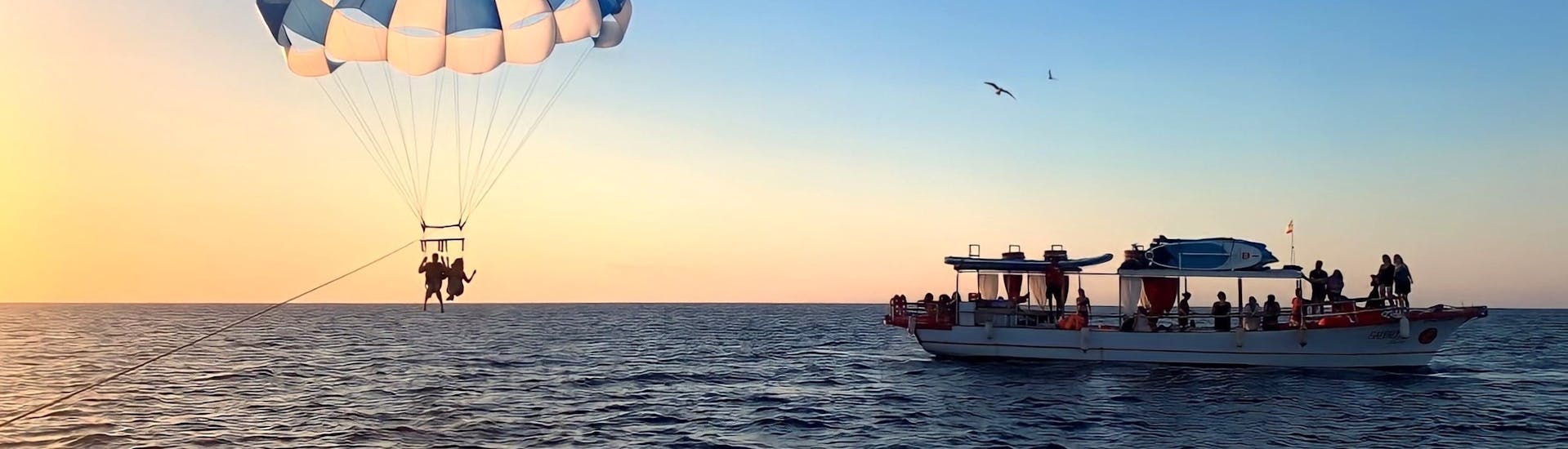 Le bateau Salvador Ibiza navigue au coucher du soleil le long de la côte d'Ibiza.
