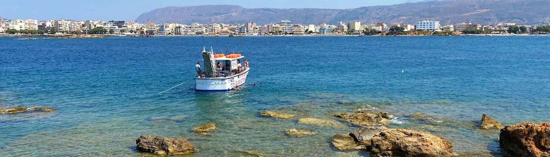 El barco del capitán Nestor se detiene en una playa durante el paseo en barco con fondo de cristal de Chania a Lazaretta.