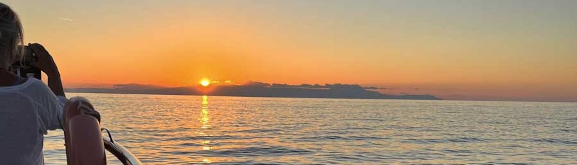 Une femme profite du coucher de soleil lors de l'excursion en bateau à fond de verre à Lazaretta au coucher du soleil.