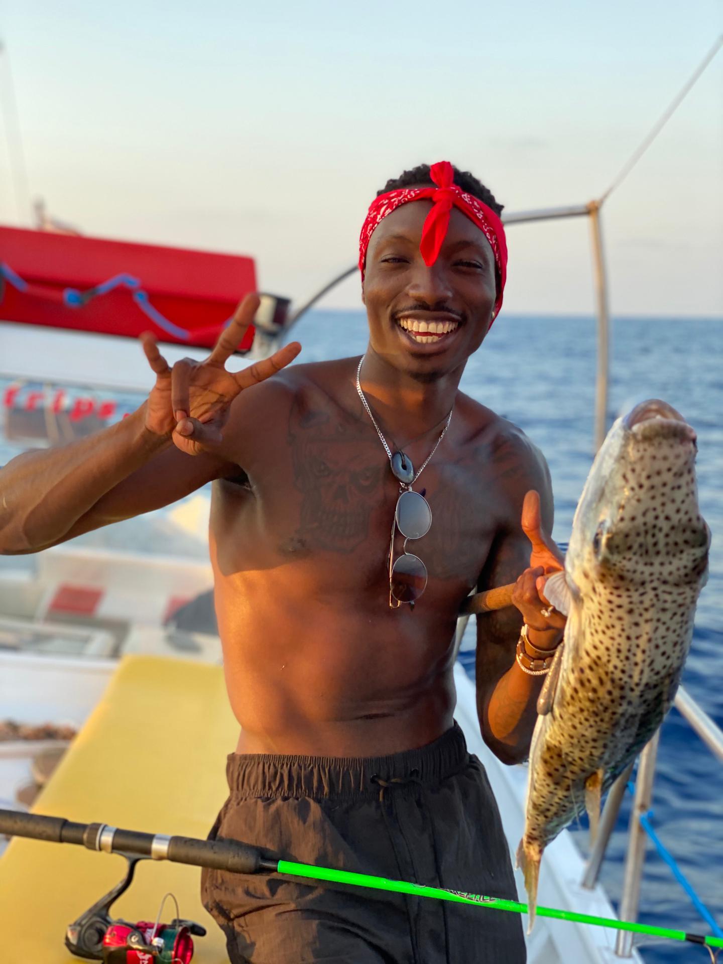 Un giovane è felice per il suo bottino durante il Giro in barca di pesca al tramonto da Hersonissos con Zorbas Cruises Hersonissos.