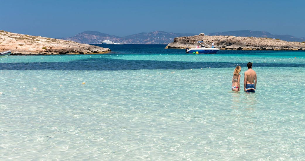 Personen im kristallklarem Wasser an einem wunderschönem Strand während der Katamaran-Tour nach Cala Saona oder Llevant mit Aperitif und Schwimmstopps.