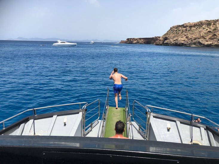 A man in jumping in the water during the Catamaran Trip around Ibiza with Water Sports activities with Sea Experience Ibiza.
