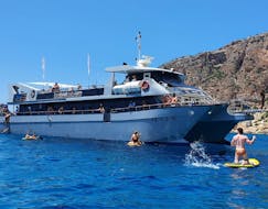 Personen beim Schwimmen und ins Wasser springen während der Katamaran-Tour rund um Ibiza mit Wassersport und Paella mit Sea Experience Ibiza.