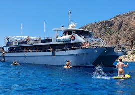 Personen beim Schwimmen und ins Wasser springen während der Katamaran-Tour rund um Ibiza mit Wassersport und Paella mit Sea Experience Ibiza.