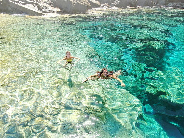 Due partecipanti si divertono nel mare durante la Gita in gommone privato attorno al Parco Nazionale dell'Asinara con aperitivo con Amato Escursioni Asinara.