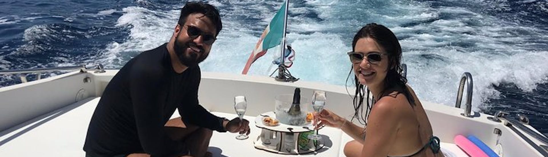 Una pareja disfrutando de unas copas durante el viaje en barco privado a la Gruta Azul y Capri con Snorkeling con Giuliani Charter Sorrento.