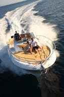 Plusieurs personnes sur un bateau de location avec skipper de Es Vedrà Charter Ibiza naviguant autour d'Ibiza à pleine vitesse.