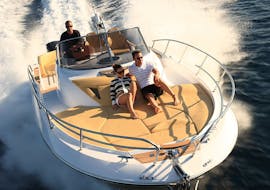 Een aantal mensen op een Es Vedrà Charter Ibiza in een gehuurde boot met schipper die op volle snelheid rond Ibiza vaart.