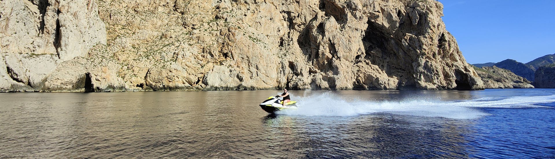 A client of the jet ski safari of Es Vedrà Charter Ibiza driving near Es Vedrá Island.