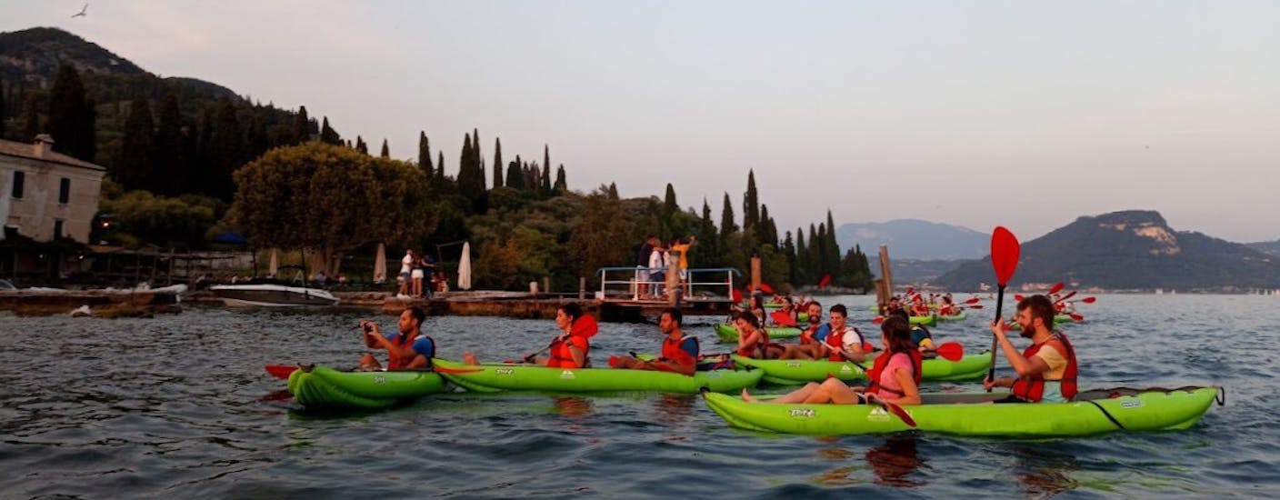 Eine Gruppe bei der Kajaktour bei Sonnenuntergang auf dem Gardasee für Familien und Freunde.