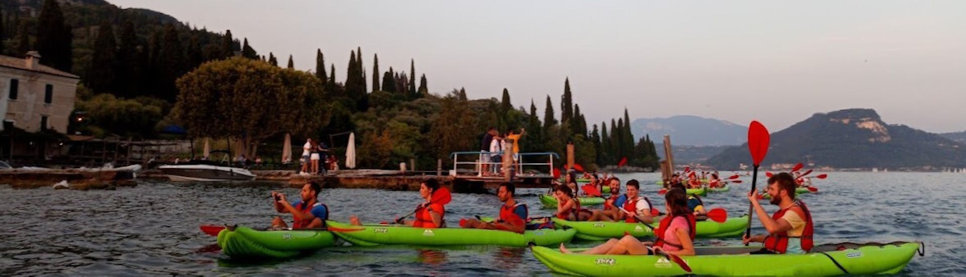Eine Gruppe bei der Kajaktour bei Sonnenuntergang auf dem Gardasee für Familien und Freunde.