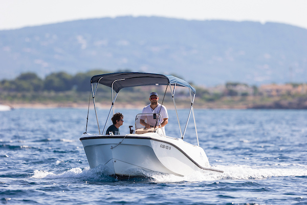 Two boys navigating on a boat without license of Alize Boats Can Pastilla in the Bay of Palma.
