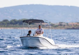 Zwei Jungs navigieren an Board von Alize Boats Can Pastilla ohne Führerschein in der Bucht von Palma.