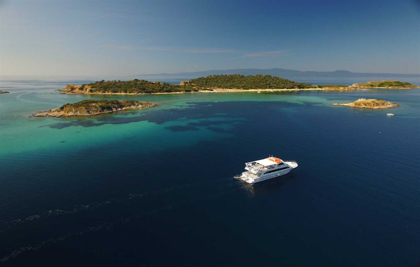 Bateau dans les eaux bleues de Crète avec un magnifique paysage des îles pendant Excursion en bateau vers le Mont Athos et l'île d'Ammouliani avec Eirinikos Glassbottom Daily & Private Cruises.
