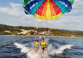 Un padre e sua figlia si divertono come matti durante il Parasailing a Ouranoupoli in Calcidica con Poseidon Water Sports Ouranoupoli.