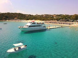 Bateau à fond de verre dans le port de la plage d'Alikes à Amouliani avec de nombreuses personnes à bord durant Excursion en bateau vers Vourvourou et l'île d'Ammouliani avec BBQ et snorkeling avec Eirinikos Glassbottom Daily & Private Cruises.