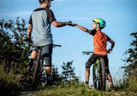 Bambini che si divertono durante il noleggio di mountain bike intorno al lago di Annecy con K2 Outdoor Annecy.