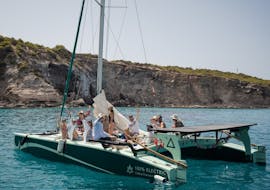 Een groep vrienden heeft plezier op de catamaran tijdens de privé dagtrip met een catamaran rond Ibiza met snorkelen met La Bella Verde Ibiza.