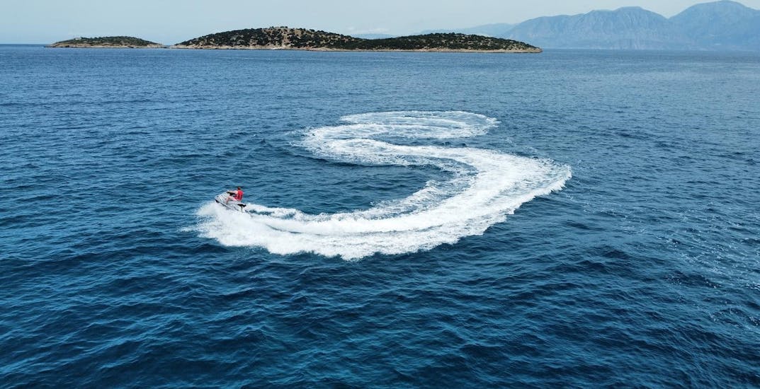 Un homme fait des virages serrés lors du Jet Ski sur la plage d'Ammoudi à Agios Nikolaos avec Amoudi Watersports.