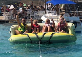 A group of friends on the crazy sofa during the Crazy Sofa, Rings & Sliders Rides at Ammoudi Beach with Amoudi Watersports.