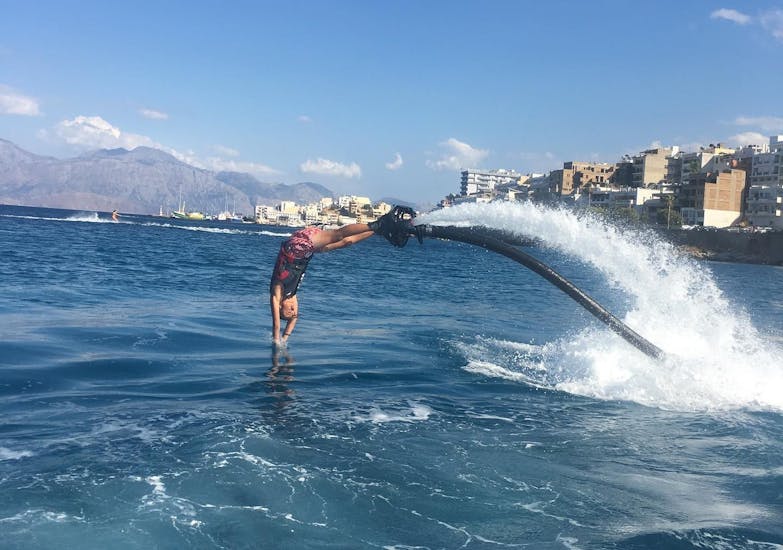 Quelqu'un plonge dans l'eau lors du Flyboard sur la plage d'Ammoudi à Agios Nikolaos avec Amoudi Watersports.