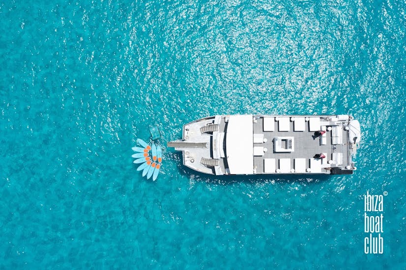 A big catamaran enjoying a boat party in Ibiza with open bar and DJ with Ibiza Boat Club.